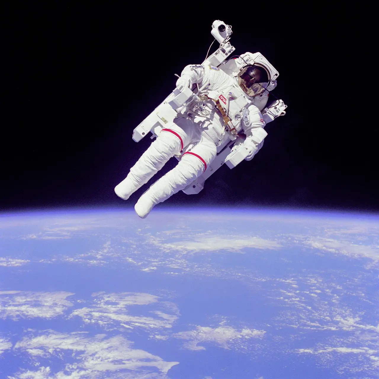 An astronaut floating free in space above the blue curve of the Earth